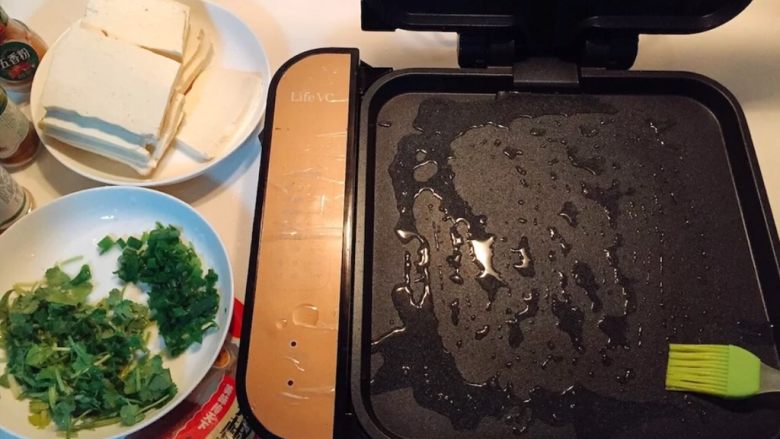 铁板豆腐,煎烤机预热3分钟,然后刷油。