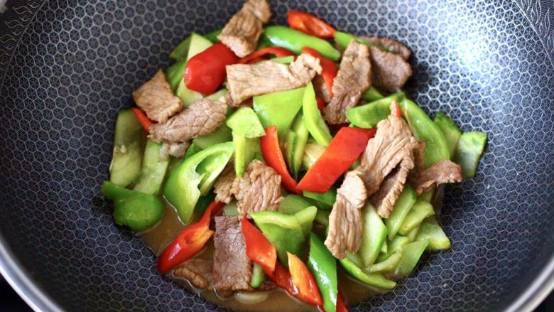 黄瓜双椒炒肉便当,大火快速翻炒至青红尖椒断生变色,进即可关火。