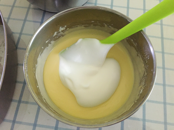 轻乳酪蛋糕,将打发好的蛋白取3分之一加入到蛋黄奶酪糊里,翻拌均匀。