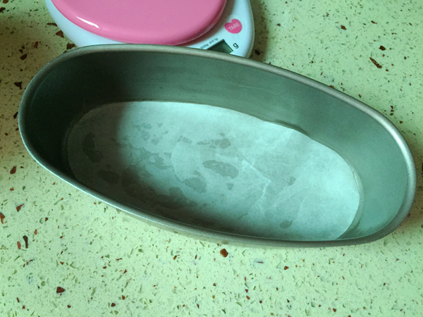 轻乳酪蛋糕,模具底部垫上油纸,另取黄油涂抹模具壁四周。