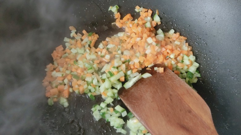 想念鸡蛋的炒饭,热锅粮油，放入胡萝卜丁和黄瓜丁，炒至变色