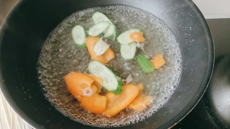 黄金与白玉的多彩多姿,锅中水放入胡萝卜和黄瓜片,继续煮