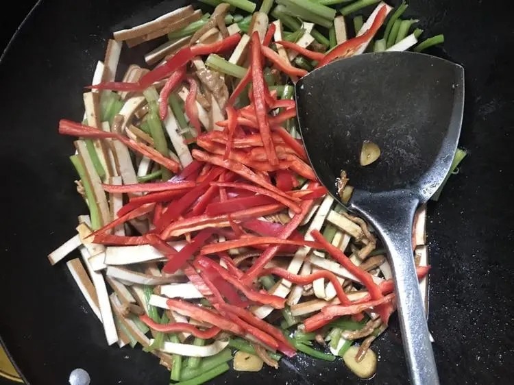 豆干炒芹菜,放入豆干,香芹继续翻炒,炒到香芹微变色,放入辣椒丝翻炒均匀即可出锅。