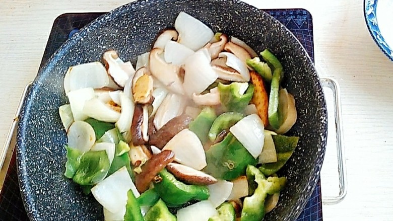 下饭神器黄焖鸡,锅中放入葱姜蒜,加入准备好的蔬菜煸炒。