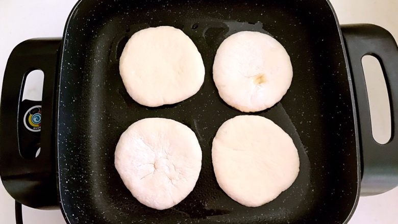 驴肉火烧,锅干烧至5分热的时候放入饼坯,