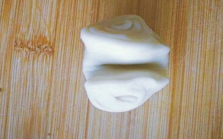 玫瑰鲜花饼,取一个卷,用手指在中间按压一下,将两头向中间捏拢