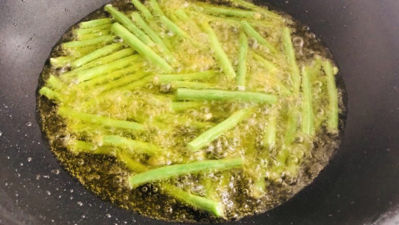超级下饭的茄子炒豆角,不能少了它,油热后下入豆角。