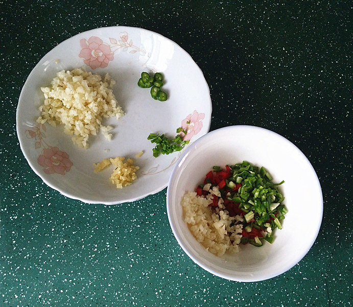 蒜香青口贝,将青红椒碎丁和部分蒜蓉等放入小碗中,余下蒜蓉放另一盘中,如图