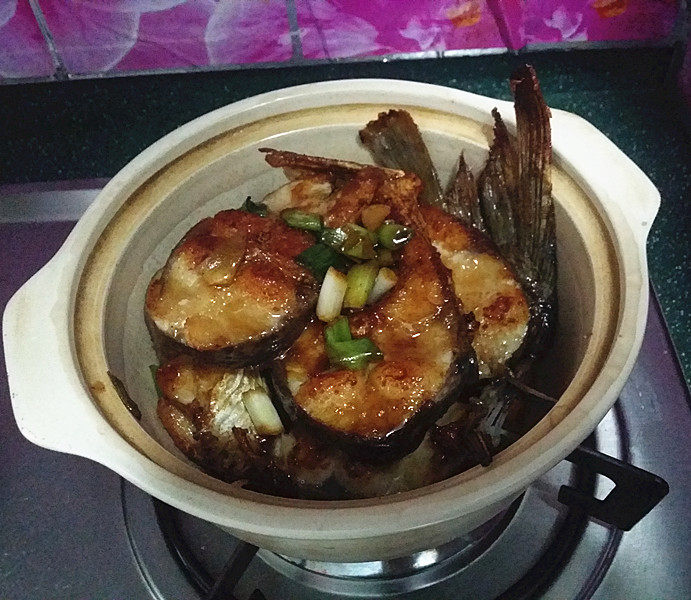 冬日暖心菜 砂锅焗鱼块,待砂锅烧热后,放入刚刚煎好的鱼块,再倒入腌鱼的卤汁