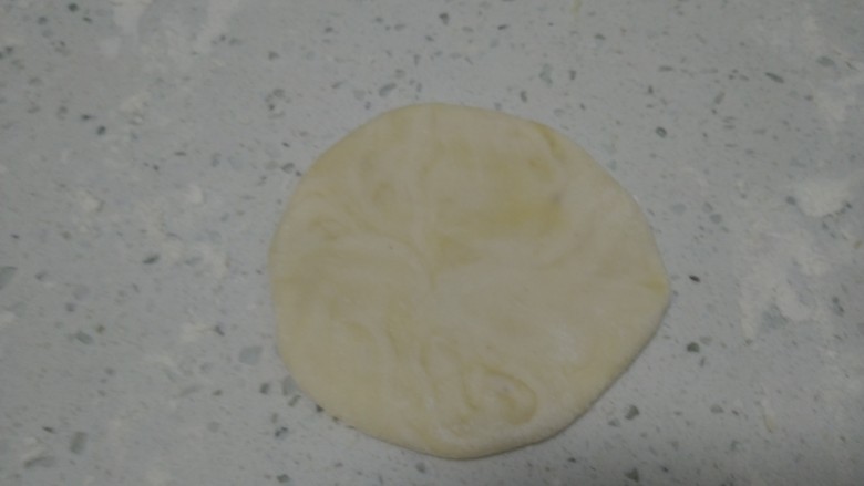 烙五仁月饼,再将两头对折到中间,擀成薄片。