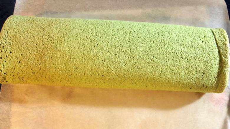 抹茶蛋糕卷,双手将蛋糕两边拎起来,把蛋糕卷成圆形后,放冰箱冷藏1个小时