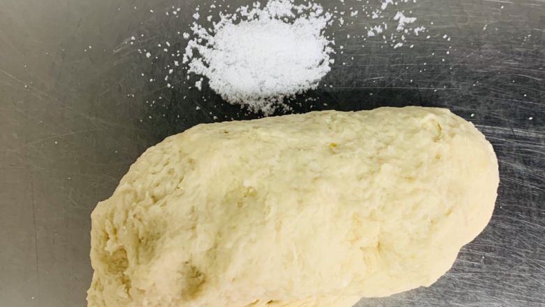榴莲披萨🍕,将揉好的面团从盆中取出放在案板上加入盐继续揉匀,将揉好的面团,平均分成两个面剂