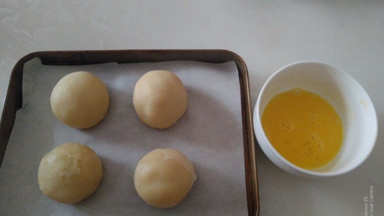 江豆蛋黄酥,放入烤盘中,准备好蛋黄液。