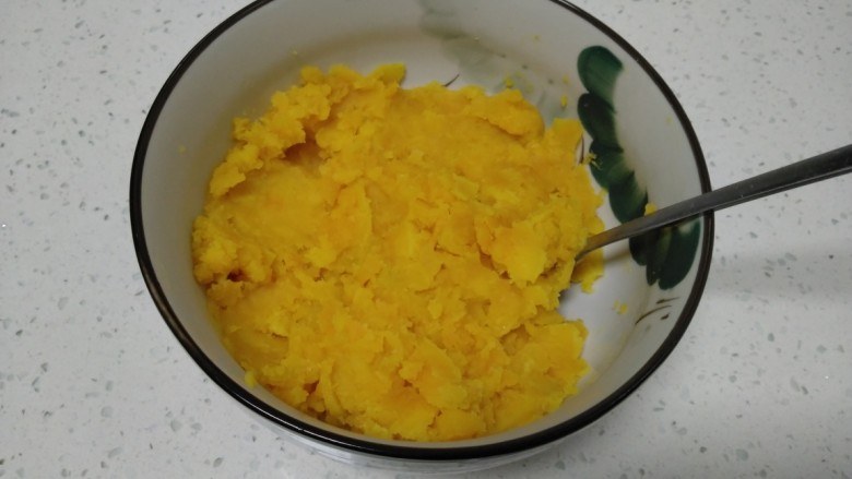 红薯、糯米、豆沙芝麻小饼,趁热用擀面杖一头捣成泥,倒入碗里。