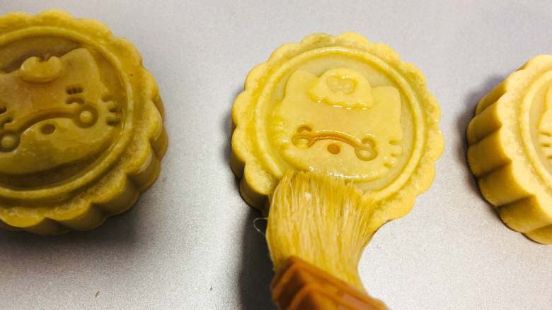 卡通萌趣月饼,取出稍微放凉,用羊毛刷刷上薄薄的一层蛋液,