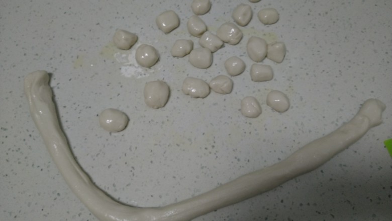 糖油酥脆糯米疙瘩,操作台上均匀涂上食用油(由于面团很软,不涂油会很粘),把面团搓成长条,分成均匀的小剂子。