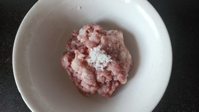 玉米秋叶煎饺,加入两克盐，以一百克猪肉一克盐的分量计算，搅拌，在摔打上劲，这样可使肉吃起来的时候更有弹性。