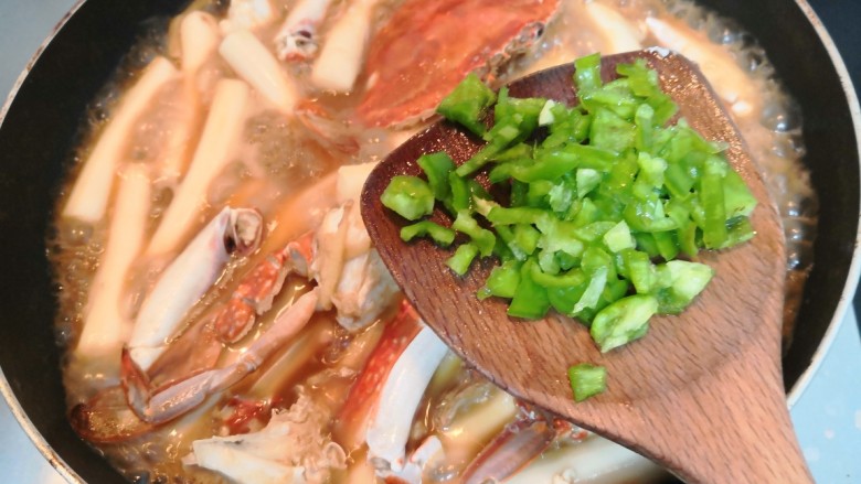 蟹炒年糕,煮至汤汁浓稠,放入青椒沫