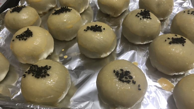 酥到掉渣的豆沙蛋黄酥,你要来一个吗?,刷蛋液,撒<a style='color:red;display:inline-block;' href='/shicai/ 668'>黑芝麻</a>。放入预热好的烤箱,上下火180度烤25-30分钟即可。