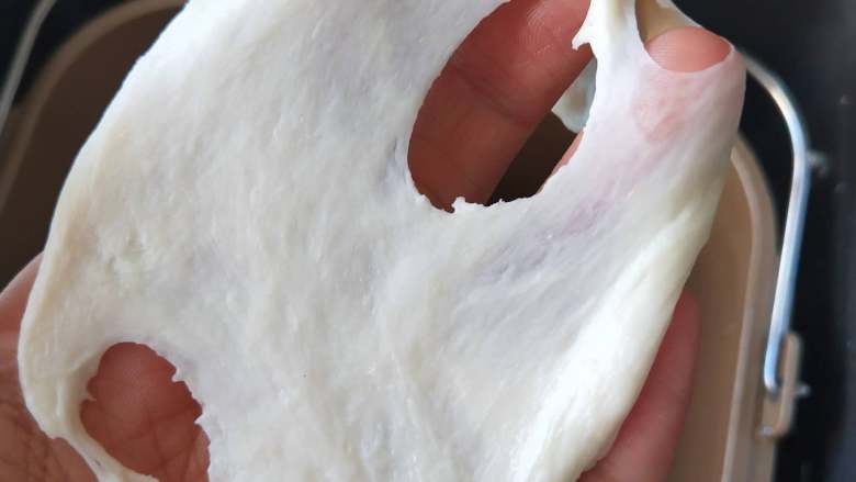 北海道牛奶土司,８、揉到扩展阶段，能拉出膜，但是边缘有锯齿状态是加入黄油继续揉。
