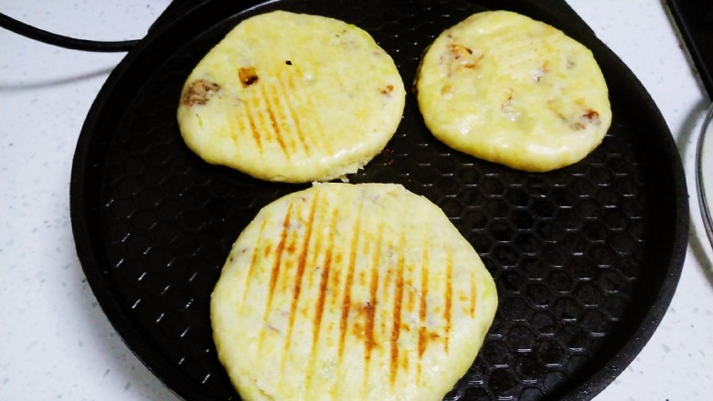 南瓜、红糖、花生、芝麻饼,包入馅料收紧口,用手压扁,放入预热好的电饼铛中,煎至一面金黄。
