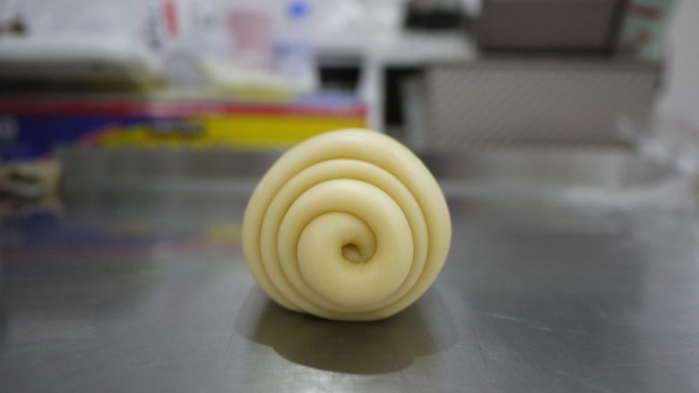 一次发酵的手撕吐司,面团无需松弛，直接又擀成长条，约40厘米，再次卷起。