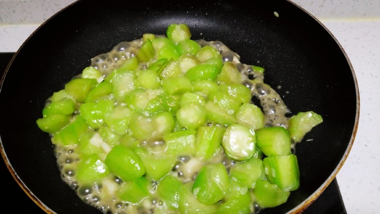 西红柿手擀面拌丝瓜菜,锅中放入适量油,炒香葱、蒜,放入丝瓜炒至断生。