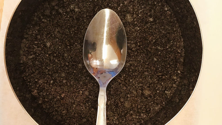 巧克力慕斯蛋糕,将黄油饼干碎放入模具(6寸慕斯圈)中,用勺子背面按压紧实。放入冰箱冷藏备用。