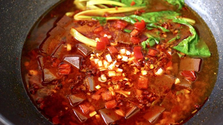 水煮猪血,看见青菜断生变色即可关火,撒上红椒和葱碎。
