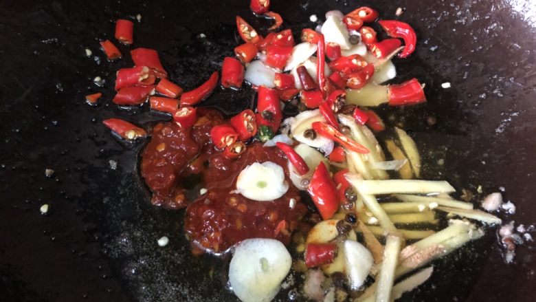 家常下饭鸭丝,再次升高油温后,下调料,郫县豆瓣一勺,其他也一起放进去,煸炒到浓烈香味。