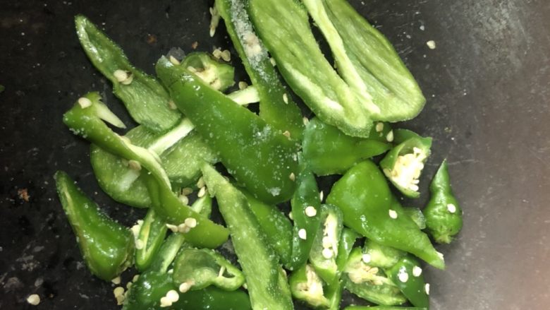 家常下饭鸭丝,青辣椒块加少量盐,在铁锅内煸炒到5分熟