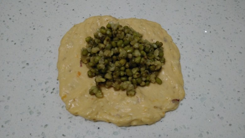 红薯、燕麦、鸡蛋、绿豆蒸面包,用手压扁,放入绿豆沙馅。