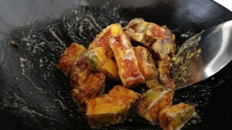 蛋黄焗南瓜,把炸好的南瓜倒入锅里,快速翻炒。