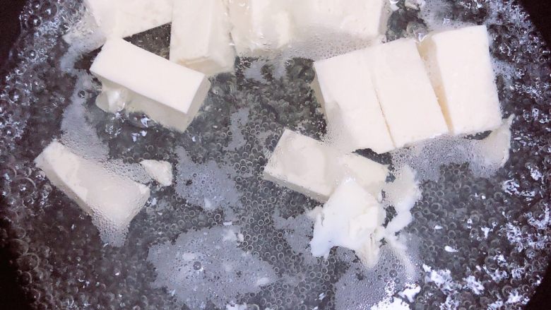 豆浆布丁,烧一锅水,把嫩豆腐放进去煮一下,去除涩味;