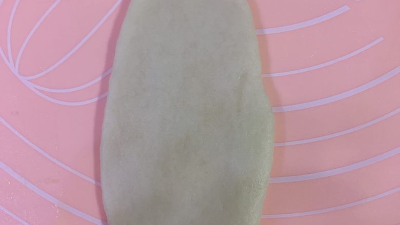 蛋黄酥,按扁轻轻擀成牛舌状,卷起,覆盖保鲜膜