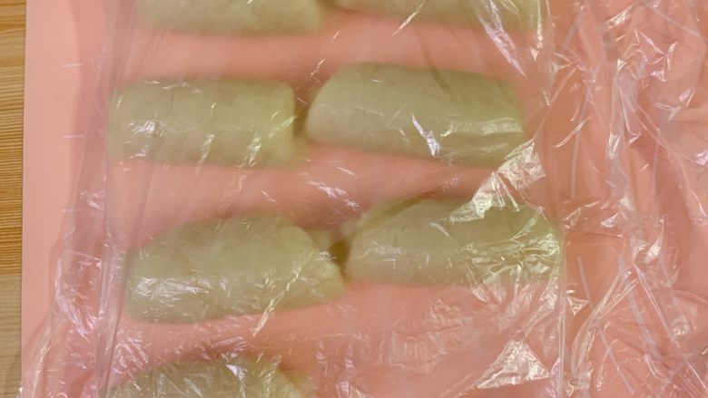 蛋黄酥,十个面团全部擀好卷起后,从第一个面团开始再次擀好卷起,覆盖保鲜膜,松弛面团