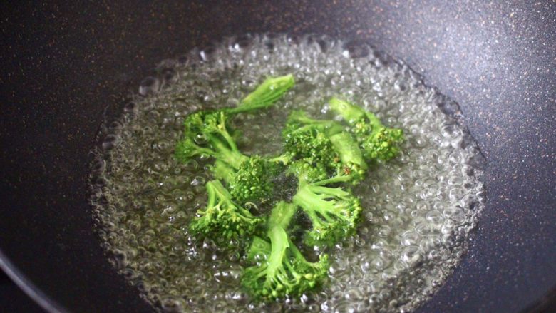 咖喱番茄丸子盖浇饭,锅中倒入适量的清水,加入少许盐和几滴食用油,把西兰花进行焯水,变色即可捞出过冷水后沥干。