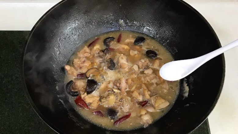 黄焖鸡,加入香菇和盐,倒入淹没过鸡块的清水,转小火焖煮约15分钟。
