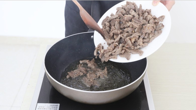麻辣牦牛肉,锅中放油,倒入焯好水的牦牛肉,当肉丝煸炒至表面略微焦黄后盛出。