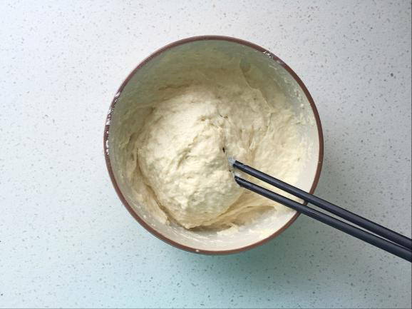红枣牛奶发糕,酵母化开后倒入面粉中,用筷子顺时针搅拌均匀;
