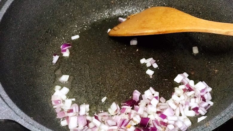 酸豆角炒饭,盛出豆腐丁后,锅中放入洋葱翻炒至透明;