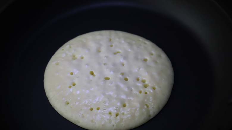 快手松饼,加热的过程中也不要去翻动松饼,耐心等待,面糊会渐渐凝固,表面出现一个个小洞,待面糊即将完全凝固的时候翻面。