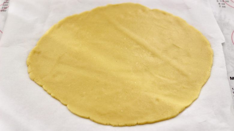 KT黄油蛋黄饼干,把面团用擀面杖擀成薄片,用油纸包好,放入冰箱冷藏30分钟。