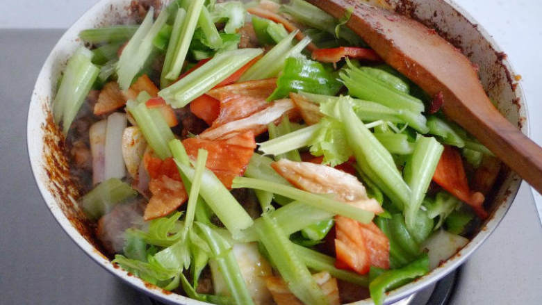 重庆鸡公煲,倒入腌制好的鸡块翻炒,加入适量的黄酒和生抽。炒至水分收干。