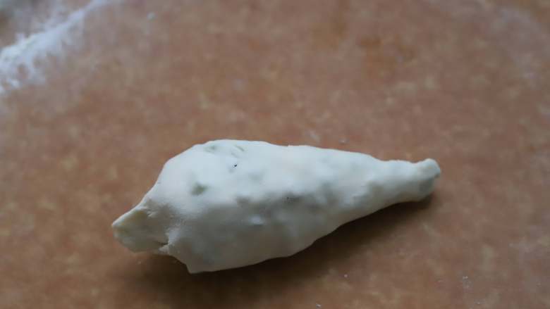 香酥葱油饼,卷好的面团底部用手捏紧收口,不然煎饼的时候底部容易散开,小葱会漏出来。