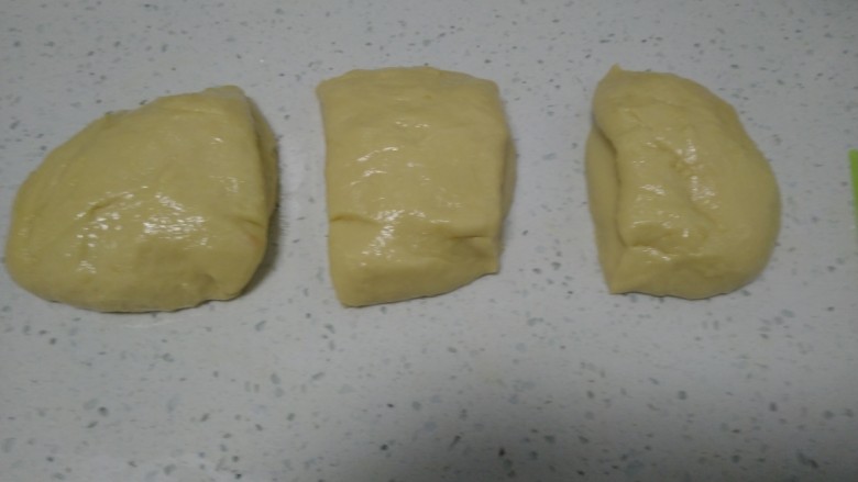 手撕面包,倒入操作台揉搓,使黄油和面粉充分融合,搓成长条平均分成3份