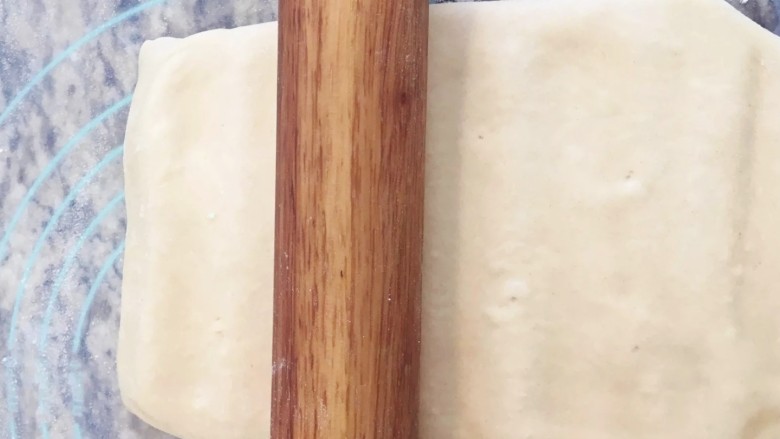 手撕面包,拿出面团把封口朝右,台面撒干粉,用擀面杖压开面团(不要直接擀这样容易边上漏油)。
压开以后再上下擀成长方形,遇到有气泡用牙签戳放气再擀,不然会破大洞。
