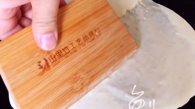 杂粮煎饼,用刮板刮圆、刮薄,动作要快