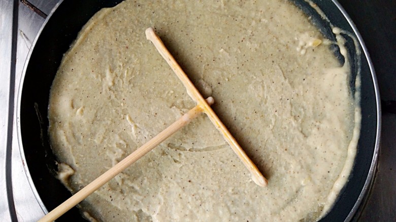 杂粮煎饼,用煎饼推子围中心打圈绕圆,把面糊在锅中推开摊平,中小火加热。(薄厚根据个人喜好)