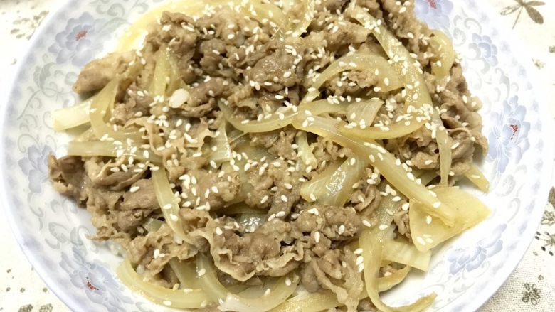 肥牛丼,将煮好的肥牛和汤汁浇在饭上,撒上白芝麻即可。